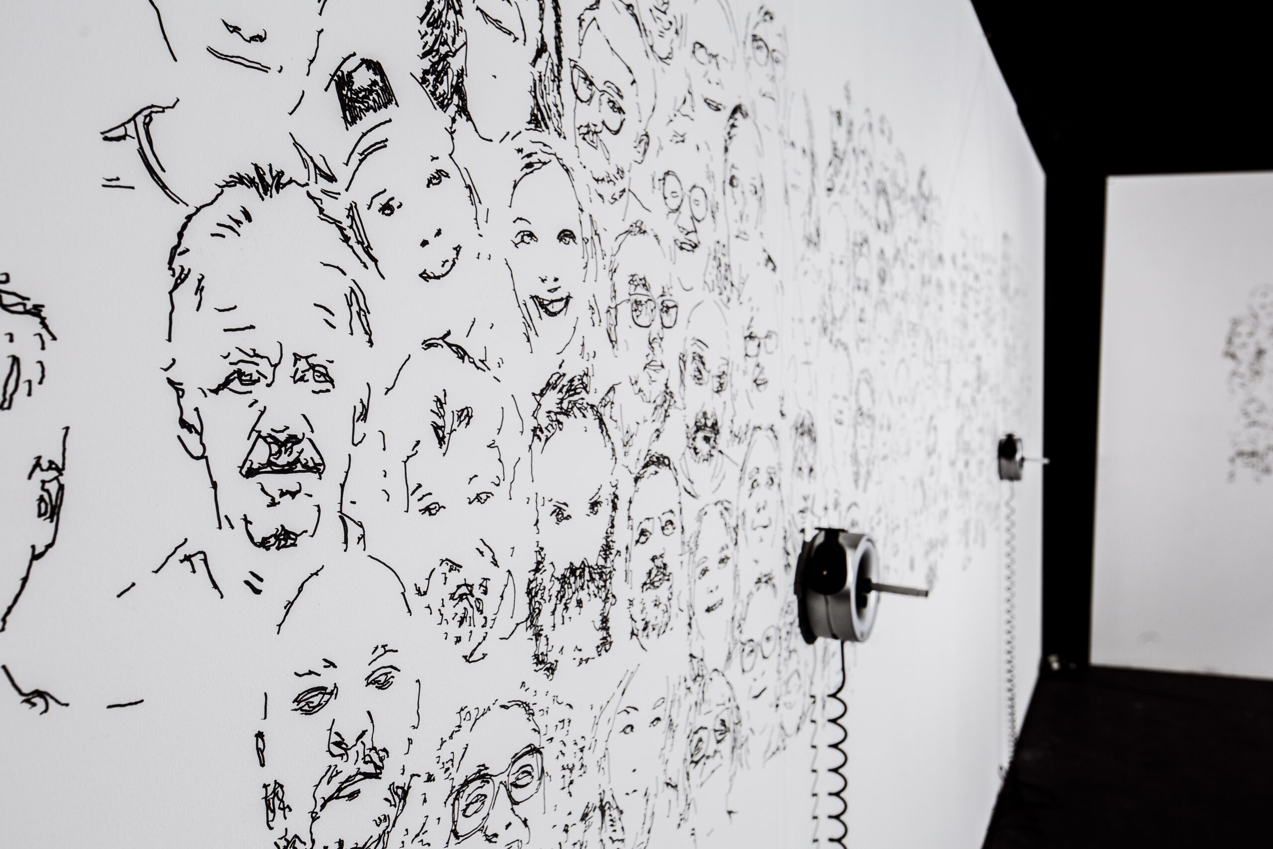 wall of faces drawn by a robot