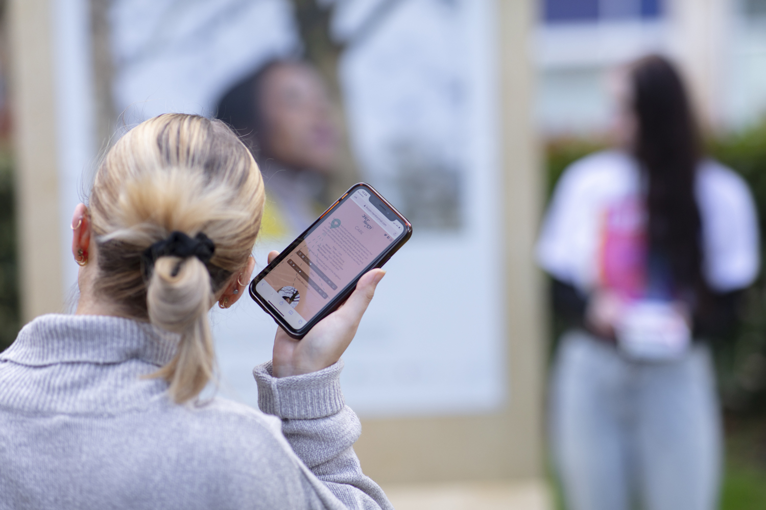 woman with blonde hair holding a phone up to ear