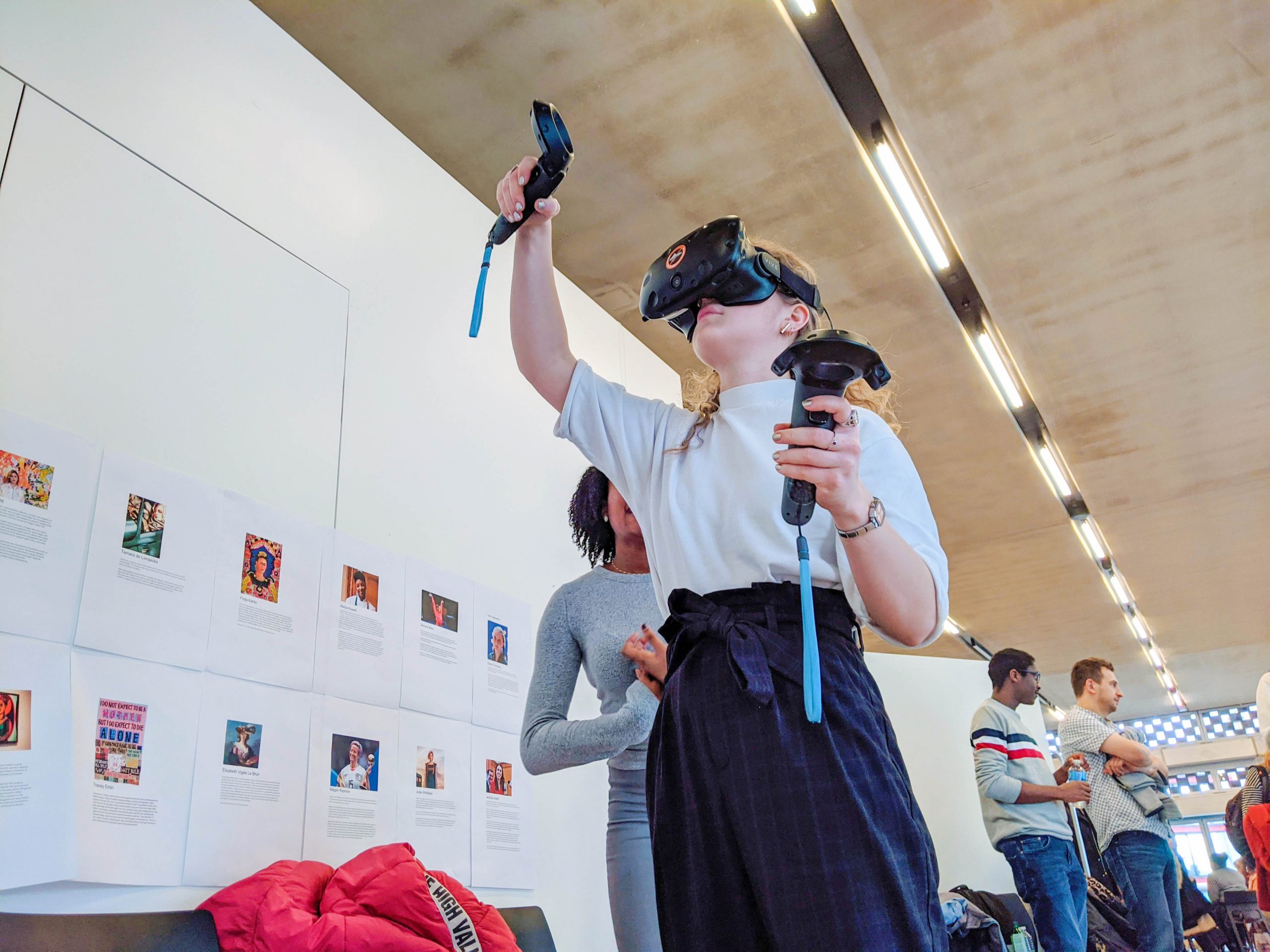 woman wearing VR headset and holding controllers. Looking up