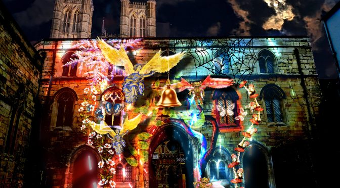 Exchequer Gate in Lincoln with projected angels and demons on it